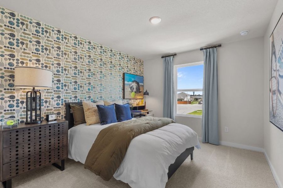 A bedroom with a bed and a lamp.