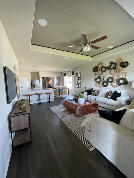 A modern living space with sleek wood floors, stylish wall art, and a cozy seating area complemented by contemporary decor.