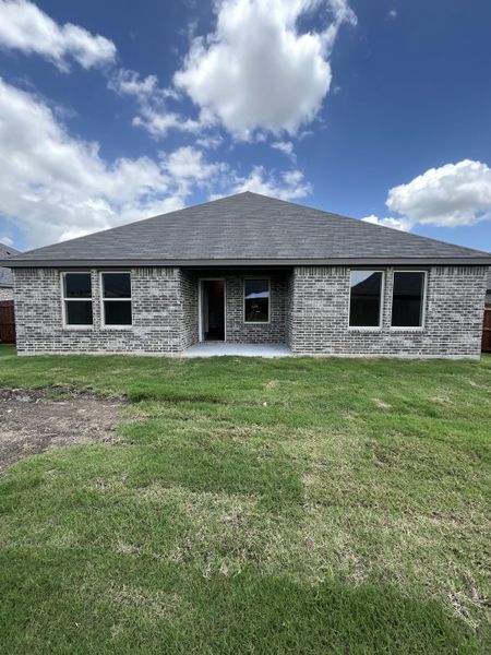 A modern brick home with expansive windows and lush lawn in Saddlebrook by D.R. Horton (Waxahachie, TX).
