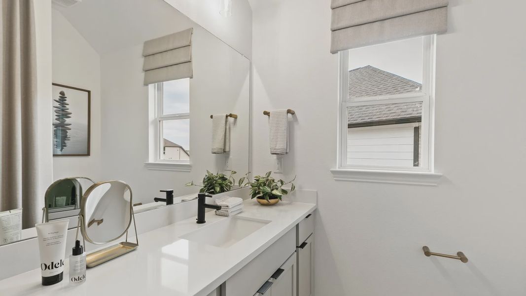 Indulge in luxury with dual-sink vanities and sleek finishes in Katy Lakes' elegant bathroom. Indulge in luxury with dual-sink vanities and sleek finishes in Katy Lakes' elegant bathroom.