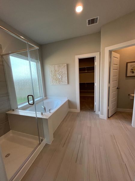 A modern bathroom with a glass-enclosed shower, spacious tub, and elegant neutral tiles. A modern bathroom with a glass-enclosed shower, spacious tub, and elegant neutral tiles.
