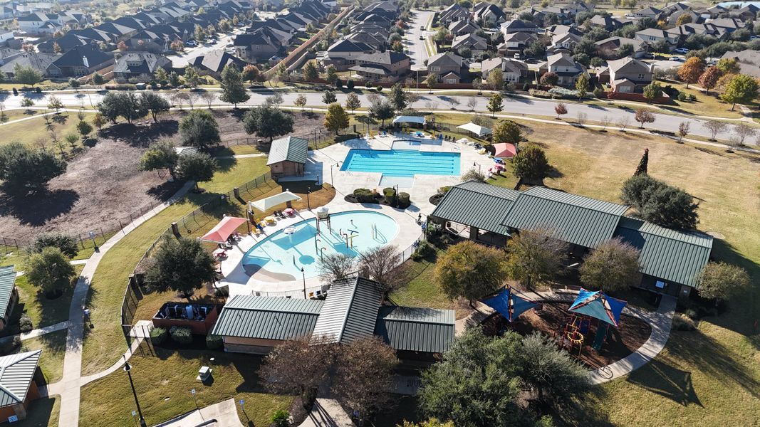 A vibrant community park with a pool and playground in Sunfield by CastleRock Communities (Buda, TX).
