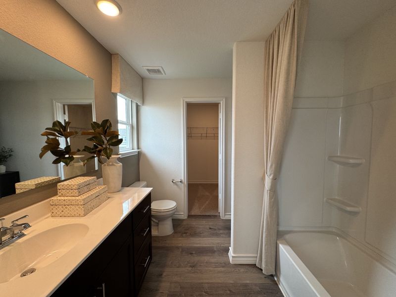 A modern bathroom featuring a sleek vanity, elegant decor, and a shower with a curtain for a serene atmosphere.