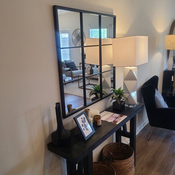 A modern entryway featuring a geometric mirror, sleek console table, and stylish decor pieces for an inviting atmosphere. A modern entryway featuring a geometric mirror, sleek console table, and stylish decor pieces for an inviting atmosphere.