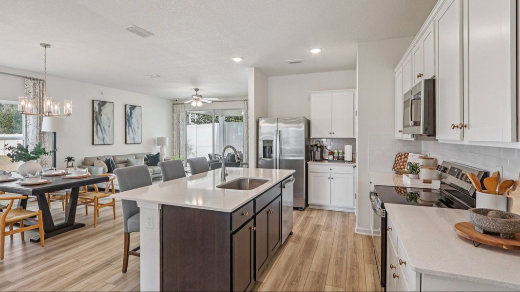 Luxurious kitchen with quartz island, stainless appliances, and designer lighting in Panther Creek. Luxurious kitchen with quartz island, stainless appliances, and designer lighting in Panther Creek.