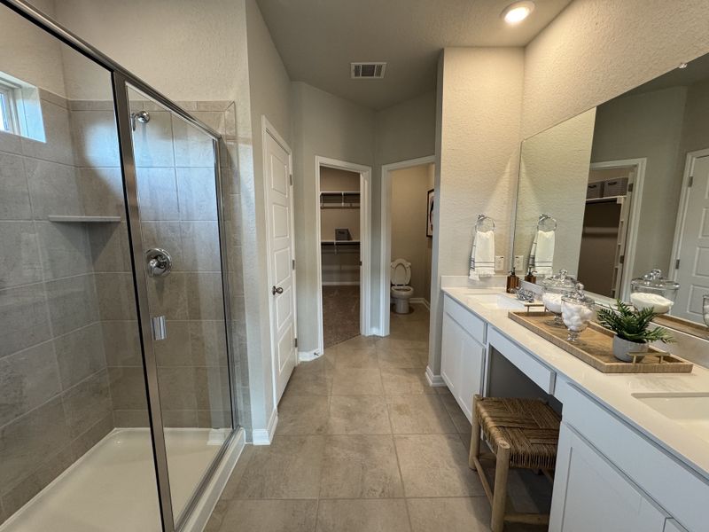 A spacious bathroom with a glass-enclosed shower, a large vanity, and soft lighting creating a relaxing atmosphere.