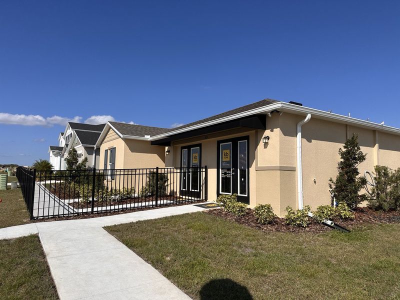 A KB Home sales center with model homes and bright blue skies in Landings at Lake Mabel Loop by KB Home (Dundee, FL).