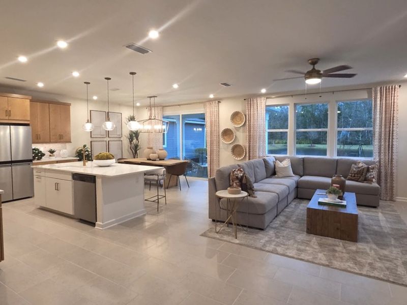 A spacious open-concept living area featuring a cozy sectional sofa, sleek kitchen island, and modern dining space.