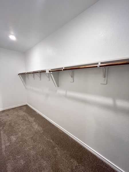 A spacious walk-in closet with plush carpeting and ample hanging space. A spacious walk-in closet with plush carpeting and ample hanging space.