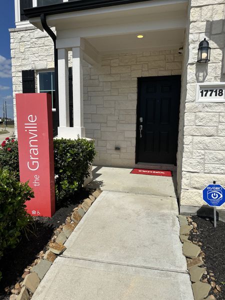 A charming stone entrance with a black door in Windrow by Centex (Hockley, TX).
