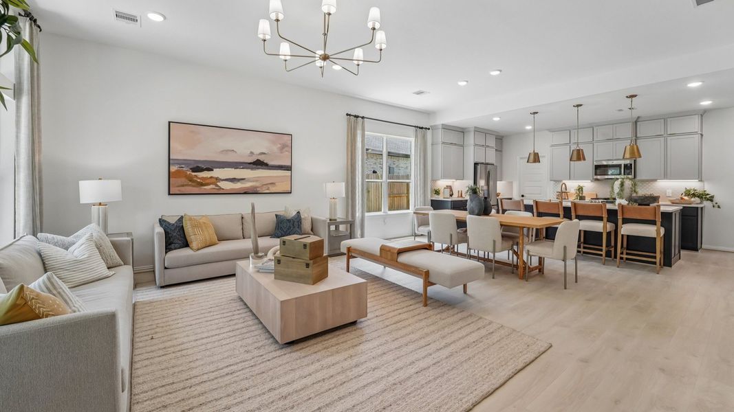 Luxurious open-plan living with chic chandelier and sleek design in The Woodlands Hills.