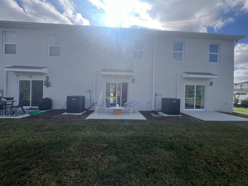 Contemporary townhome with patio and manicured lawn in Danbury at Ridgewood Lakes by D.R. Horton (Davenport, FL).