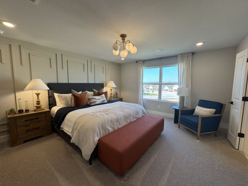 A cozy bedroom with modern paneled walls, accent lighting, and a comfortable seating area by the window.