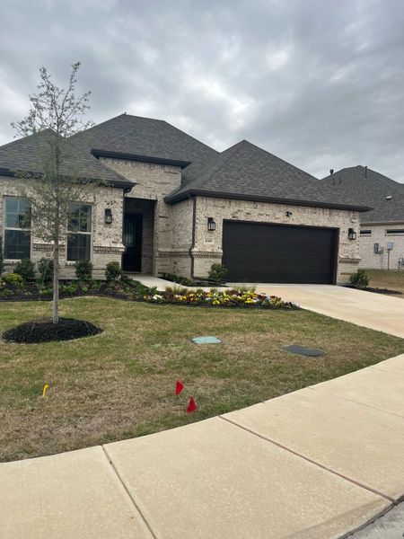A beautiful stone home with a manicured lawn and flower bed in Ladera Prosper by Ladera Texas (Prosper, TX). A beautiful stone home with a manicured lawn and flower bed in Ladera Prosper by Ladera Texas (Prosper, TX).