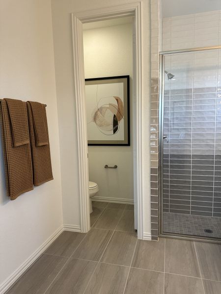 A modern bathroom with sleek gray tiles, glass shower, minimalist art, and textured towels for a sophisticated touch. A modern bathroom with sleek gray tiles, glass shower, minimalist art, and textured towels for a sophisticated touch.