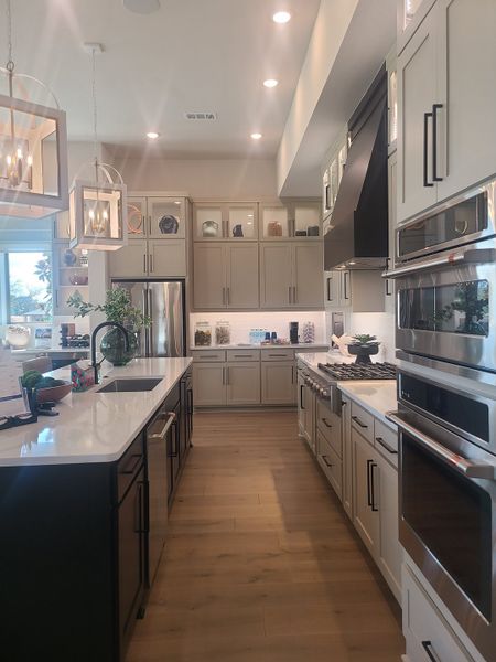 A modern kitchen featuring sleek cabinetry, dual ovens, and elegant pendant lighting with a spacious island centerpiece. A modern kitchen featuring sleek cabinetry, dual ovens, and elegant pendant lighting with a spacious island centerpiece.