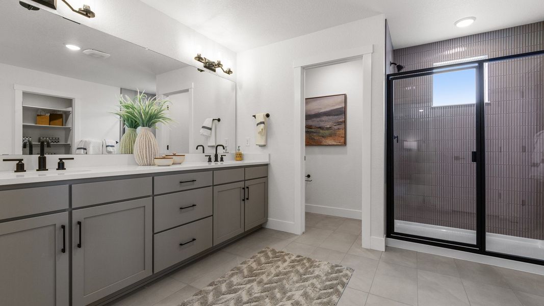 Experience elegance with a dual vanity, expansive shower, and chic modern fixtures in Bloom community.