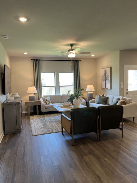 An inviting living room with elegant decor, cozy seating, wood floors, and abundant natural light.