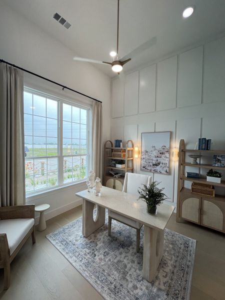 A modern office space featuring a sleek desk, decorative shelving, and large windows with elegant drapes. A modern office space featuring a sleek desk, decorative shelving, and large windows with elegant drapes.