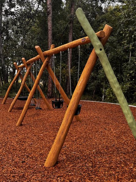 A lovely playground with wooden swings surrounded by lush trees in RiverTown - Springs by Mattamy Homes (St. Johns, FL). A lovely playground with wooden swings surrounded by lush trees in RiverTown - Springs by Mattamy Homes (St. Johns, FL).