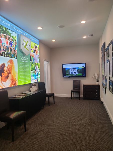 A welcoming sales office with informational displays, dark wood furniture, and a comfortable ambiance.
