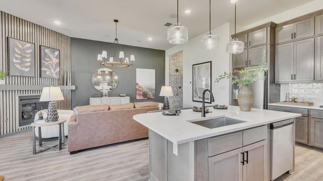 Experience elegance in Briarwood with a modern chandelier, sleek fireplace, and a sophisticated island kitchen.