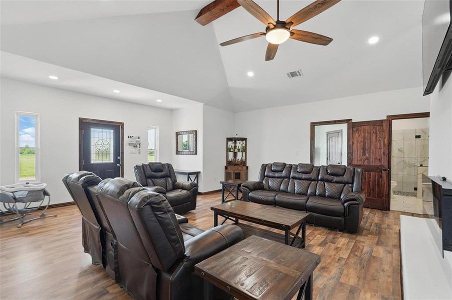 Living area with wood finished floors, recessed lighting, beamed ceiling, high vaulted ceiling, and a ceiling fan Living area with wood finished floors, recessed lighting, beamed ceiling, high vaulted ceiling, and a ceiling fan
