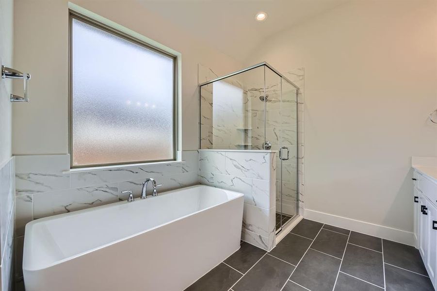 Full bathroom featuring a freestanding bath, a marble finish shower, vanity, and recessed lighting Full bathroom featuring a freestanding bath, a marble finish shower, vanity, and recessed lighting