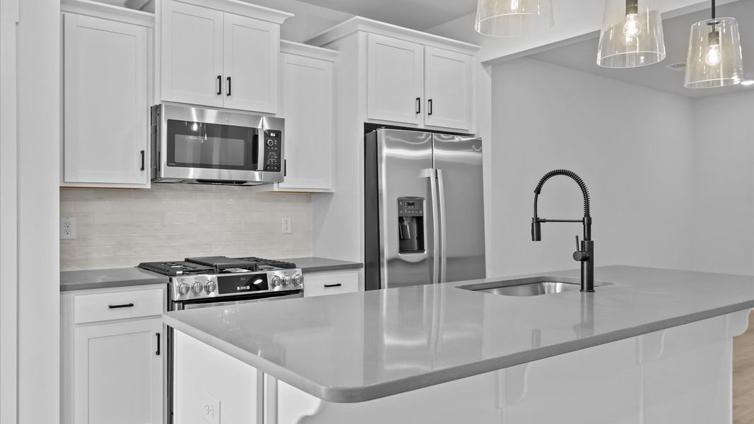 Memorable meals begin in this vibrant kitchen with pendant lighting and a thoughtfully designed island Memorable meals begin in this vibrant kitchen with pendant lighting and a thoughtfully designed island