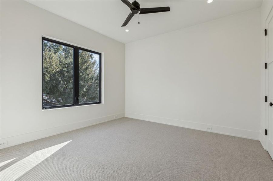 Empty room featuring ceiling fan and light colored carpet