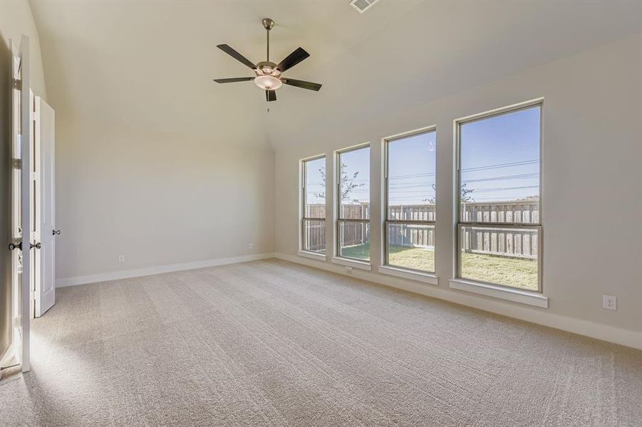 Unfurnished room with light colored carpet, lofted ceiling, and a ceiling fan