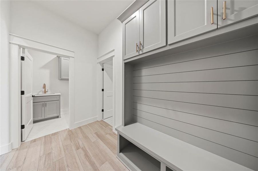 Mudroom featuring light wood-style floors and a sink