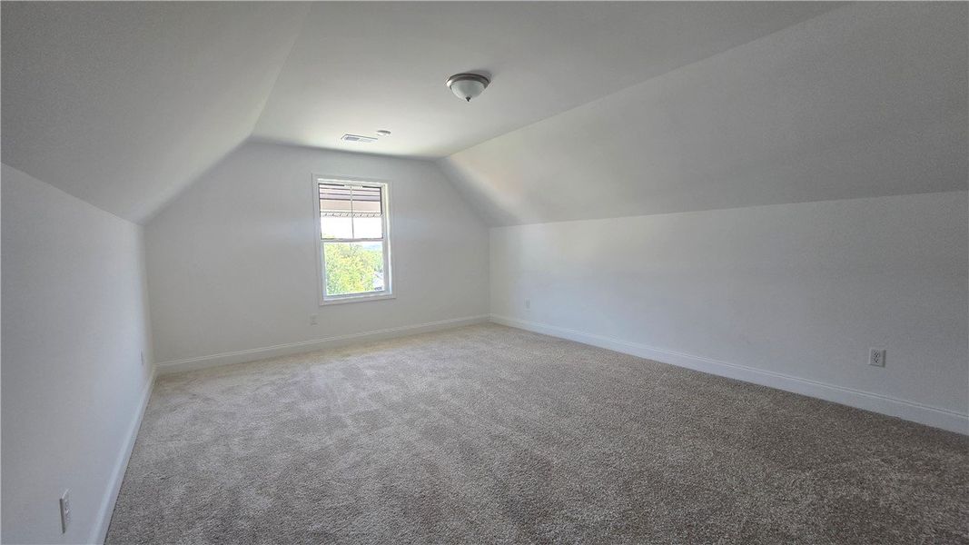 A spacious room offers comfortable carpet flooring