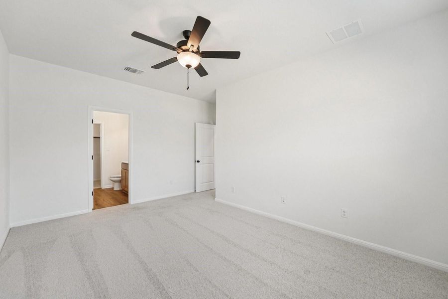 An airy bedroom with fresh carpeting connects seamlessly to an adjoining bathroom, offering comfort and privacy. An airy bedroom with fresh carpeting connects seamlessly to an adjoining bathroom, offering comfort and privacy.