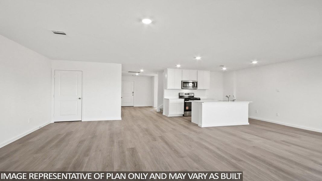 Kitchen featuring light countertops, open floor plan, light wood finished floors, and recessed lighting Kitchen featuring light countertops, open floor plan, light wood finished floors, and recessed lighting
