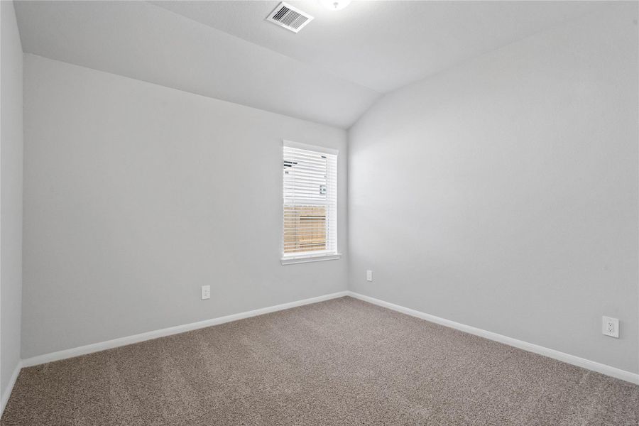 Perfect for guests or a quiet home office, this room features soft plush carpeting, a window with fitted blinds, sloped ceiling, and ample sized closet space.