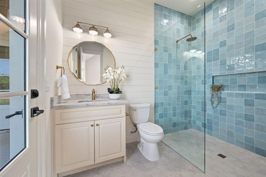 Full bath with walk in shower, vanity, light tile patterned flooring, and wood walls