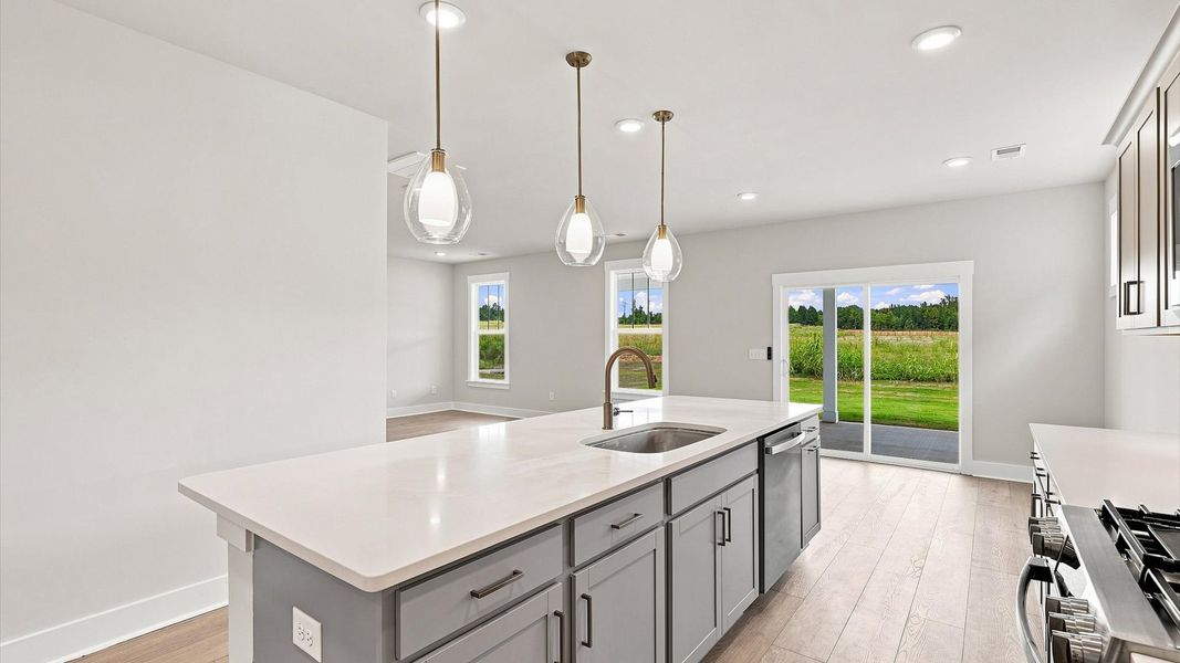 Memorable meals begin in this vibrant kitchen with pendant lighting and a thoughtfully designed island Memorable meals begin in this vibrant kitchen with pendant lighting and a thoughtfully designed island