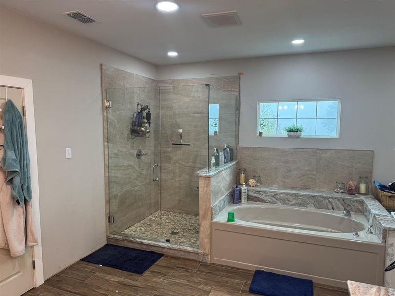 Bathroom with a bath, wood tiled floors, a shower stall, and recessed lighting Bathroom with a bath, wood tiled floors, a shower stall, and recessed lighting