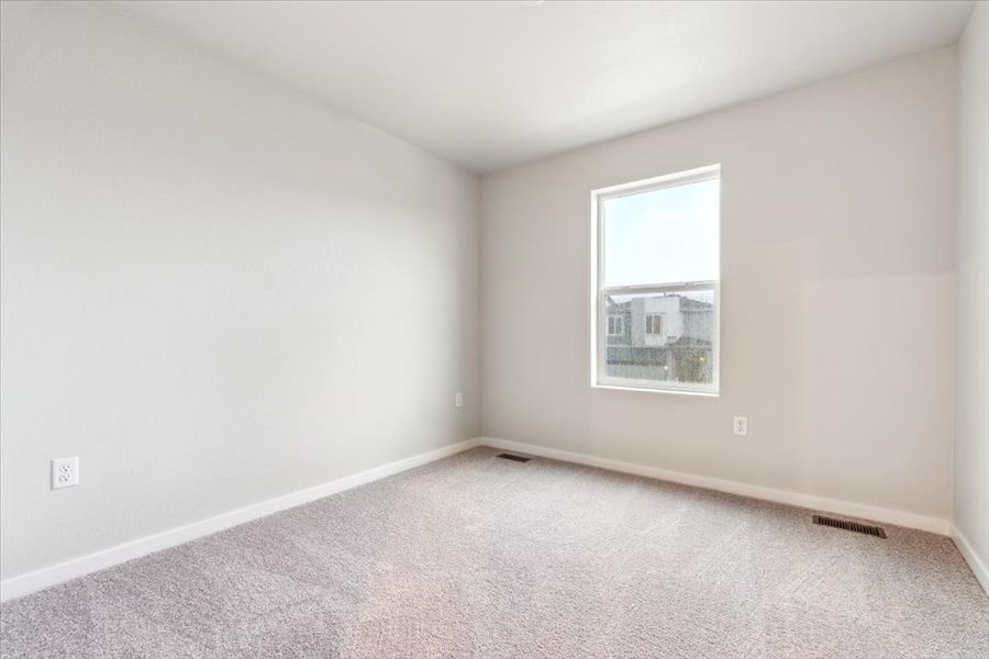 A room with a window and a carpet.
