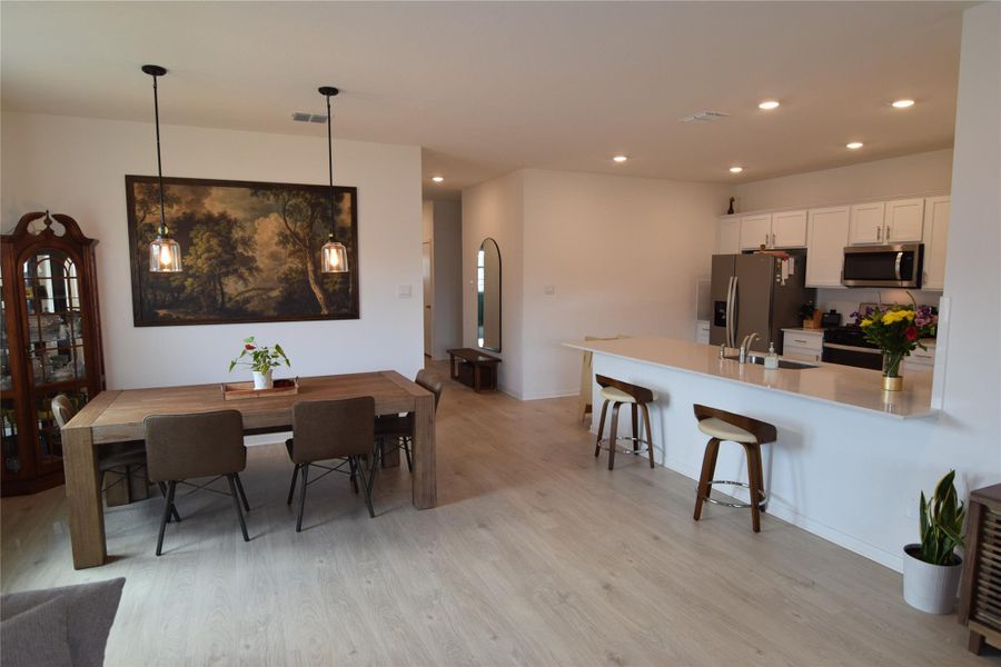 Smooth light flooring flows seamlessly from the dining area into the open-concept kitchen.