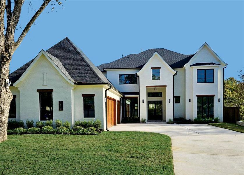 Modern farmhouse featuring concrete driveway, roof with shingles, and a front lawn Modern farmhouse featuring concrete driveway, roof with shingles, and a front lawn