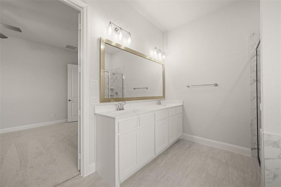 Full bath featuring a ceiling fan, a marble finish shower, and double vanity Full bath featuring a ceiling fan, a marble finish shower, and double vanity