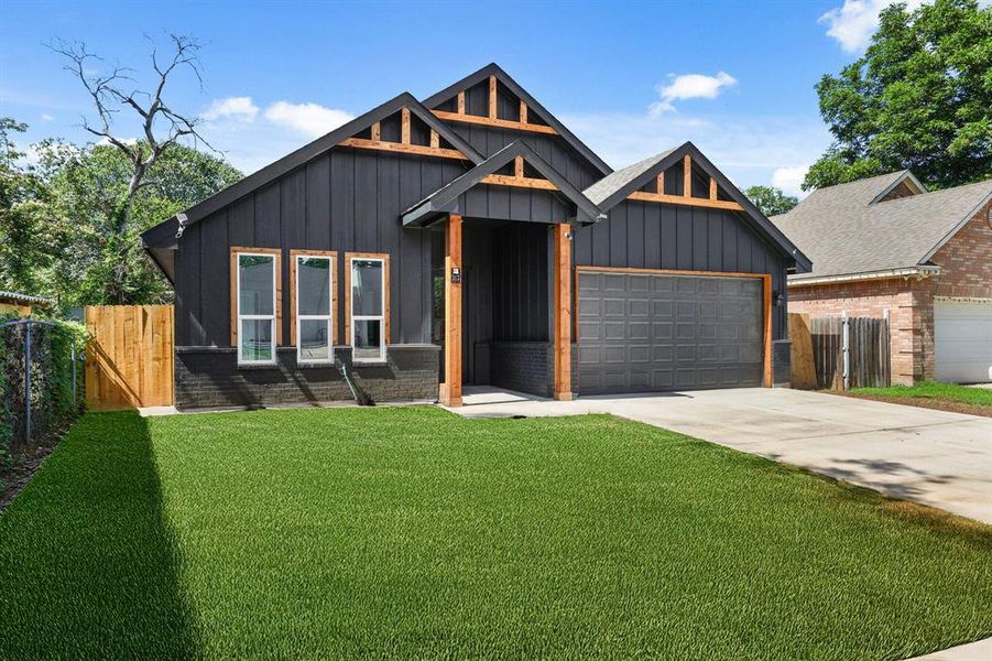 View of front of property with a garage, board and batten siding, and concrete driveway