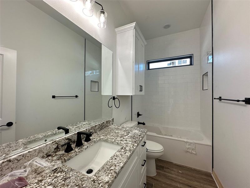 Bathroom featuring dark wood finished floors, vanity, and shower / bathtub combination