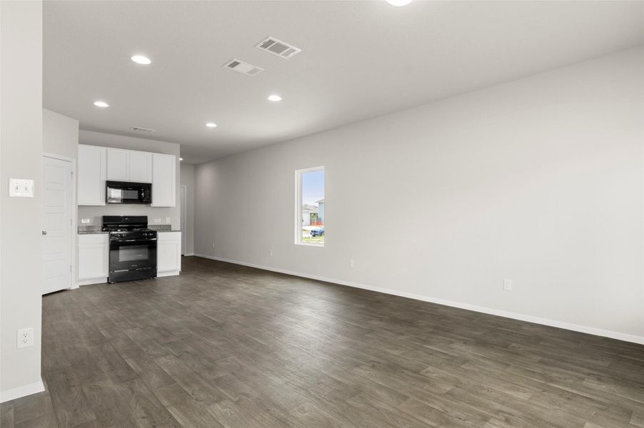 Unfurnished living room with recessed lighting and dark wood-style flooring Unfurnished living room with recessed lighting and dark wood-style flooring