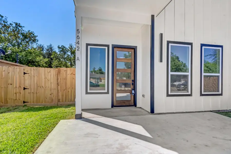 Unit A, private unit entrance featuring modern glass-panel front door and large energy-efficient windows that bring in natural light, offering a welcoming and bright entry to each residence.