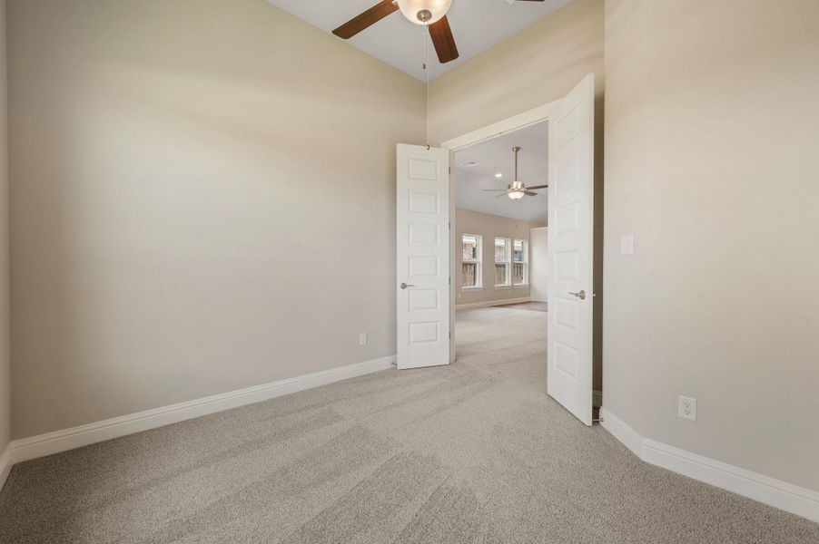 Unfurnished room with light colored carpet and ceiling fan