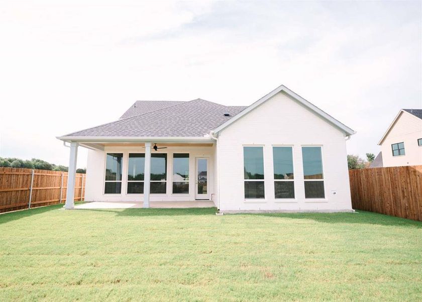 Rear view of house featuring a yard and a patio