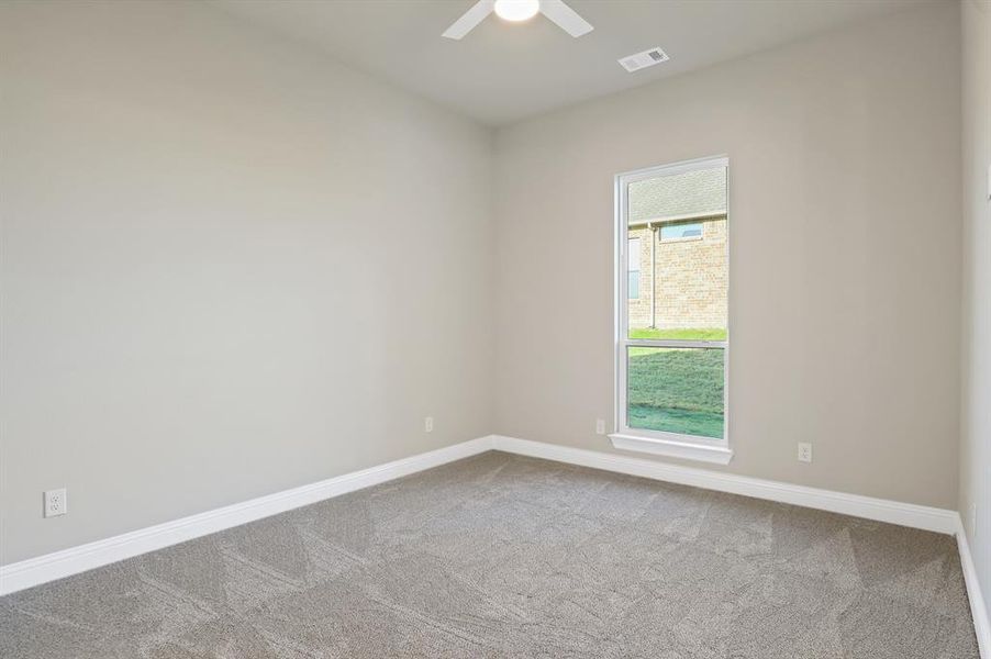 Spare room with ceiling fan and carpet flooring